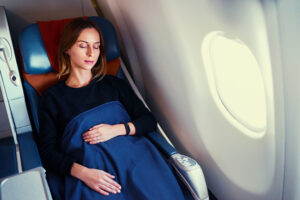 zurückgelehnte schlafende Frau in einem Flugzeugsitz